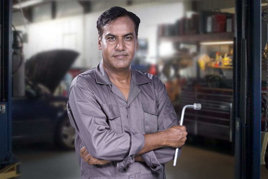 Friendly auto mechanic smiling in the workshop
